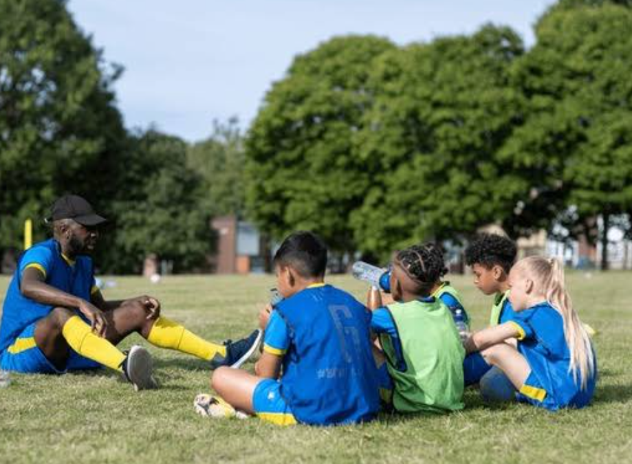 Kids resting on grass after a football session